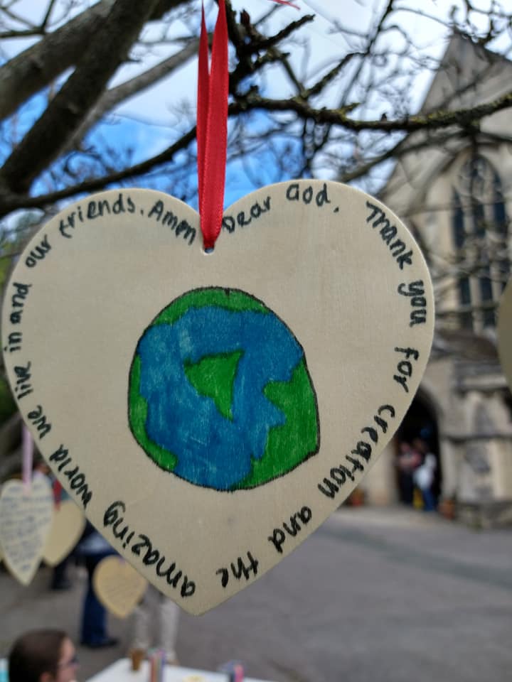 Wood heart hanging n tree.l.. pic of world and writing saying . Thank you God for crreation and this amazing world and our friiends